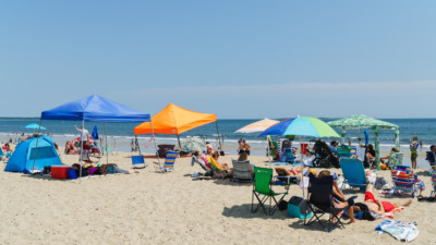 people relaxing by the beach under the tents