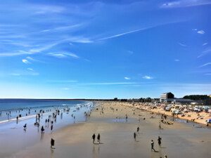 Beach scene with people and blue sky.
